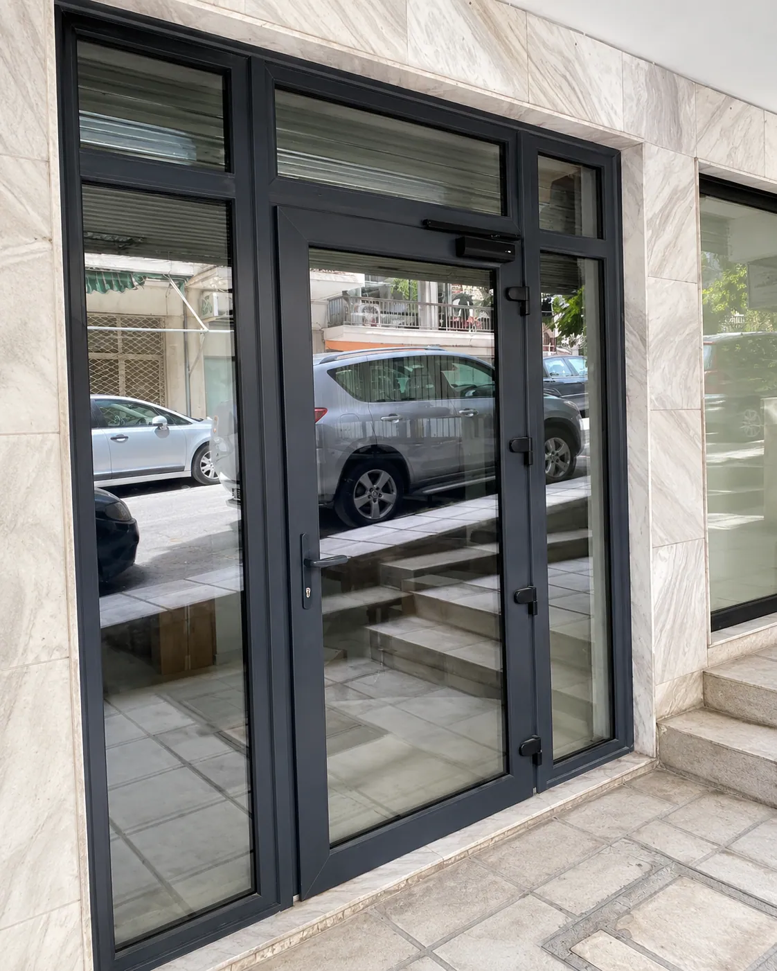 Ανθρακί υαλόπορτα αλουμινίου σε επαγγελματικό χώρο.