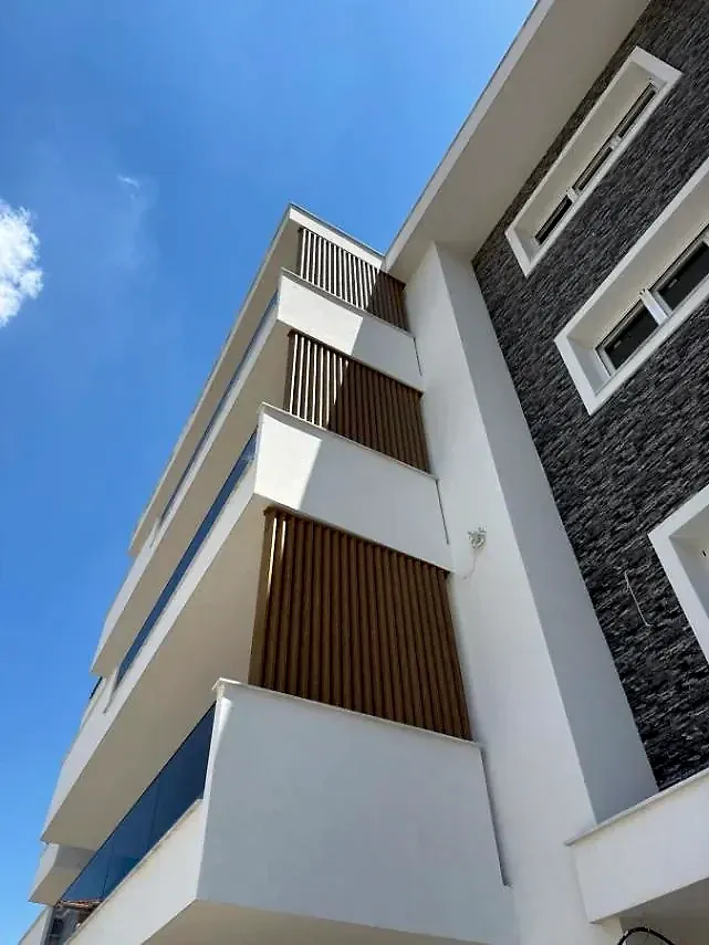 Πρόσοψη πολυκατοικίας με κάθετες περσίδες σκίασης σε απόχρωση ξύλου — έργο PalSystems στην Κοζάνη.